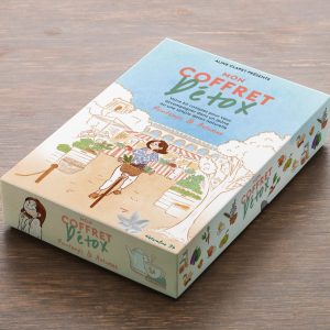Coffret « Mon Coffret Détox » présenté sur une table en bois, illustré avec une scène de marché et des éléments naturels.